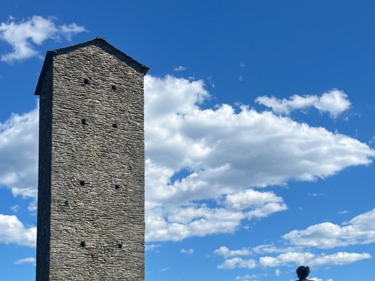 Tour en pierre sous un ciel bleu parsemé de nuages.